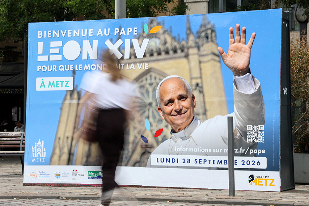 A woman walks past a poster in front of the train station in Metz, France, Sept. 9, 2026, welcoming Pope Leo XIV ahead of his visit in the northeastern French city. (OSV News/Reuters/Ardee Napolitano)