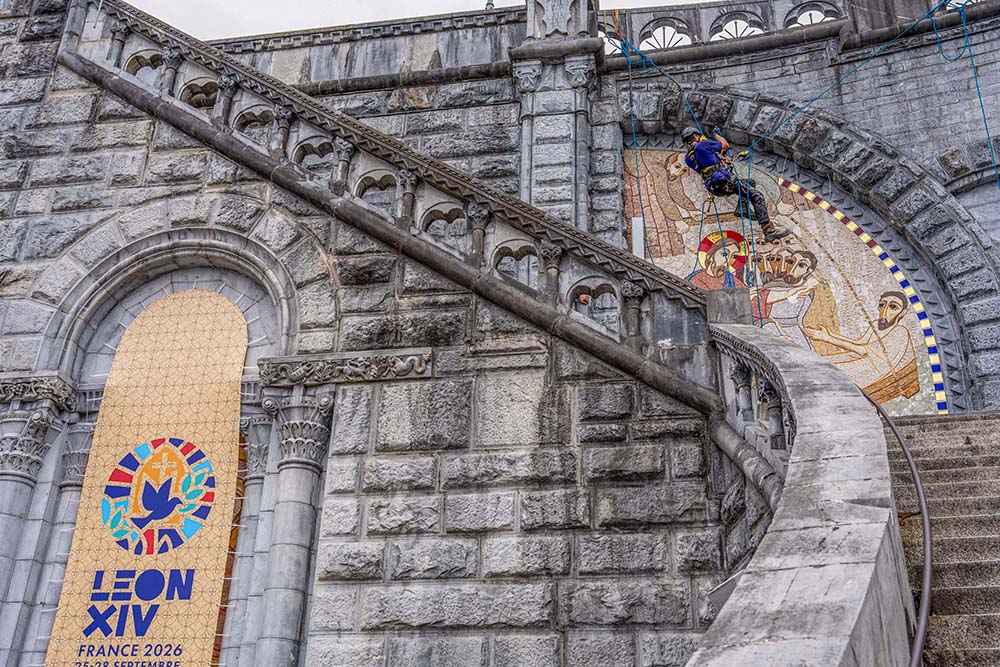 A worker covers mosaics on the facade of the Basilica of Our Lady of the Rosary in Lourdes, France, Sept. 18, 2026. The mosaics were created by former Jesuit Fr. Marko Rupnik, who has been accused of abusing more than 20 women, and were covered ahead of Pope Leo XIV’s Sept. 26 arrival in Lourdes. (OSV News/Courtesy of Lourdes Sanctuary)