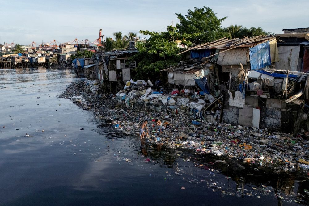 A drone view shows children picking through washed-up garbage along the polluted Pasig River in Manila, Philippines on June 5, 2025. (OSV News/Reuters/Eloisa Lopez)