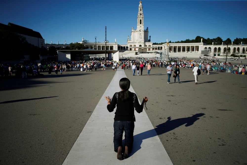 A pilgrim prays near the Marian shrine of Fátima in central Portugal May 12, 2019. In 1917, three shepherd children reported apparitions of the Virgin Mary in the fields of the Cova da Iria quarter in Fátima. (OSV News/Reuters/Pedro Nunes)