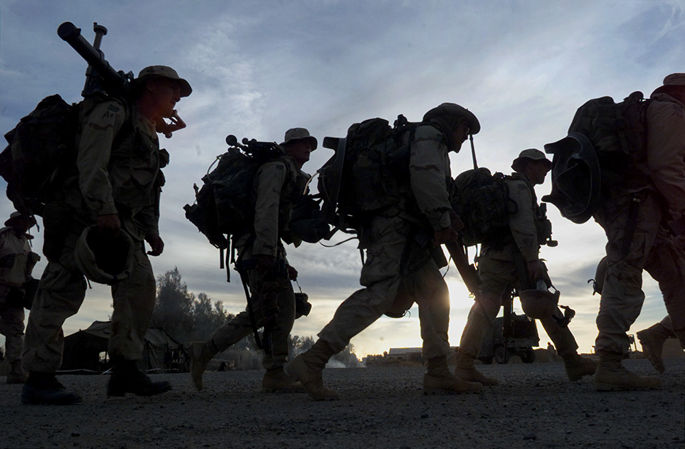 American Marines with full battle gear prepare to board transport helicopters at the U.S. military compound at Kandahar airport for a mission to an undisclosed location in Afghanistan Dec. 31, 2001. (AP/John Moore)
