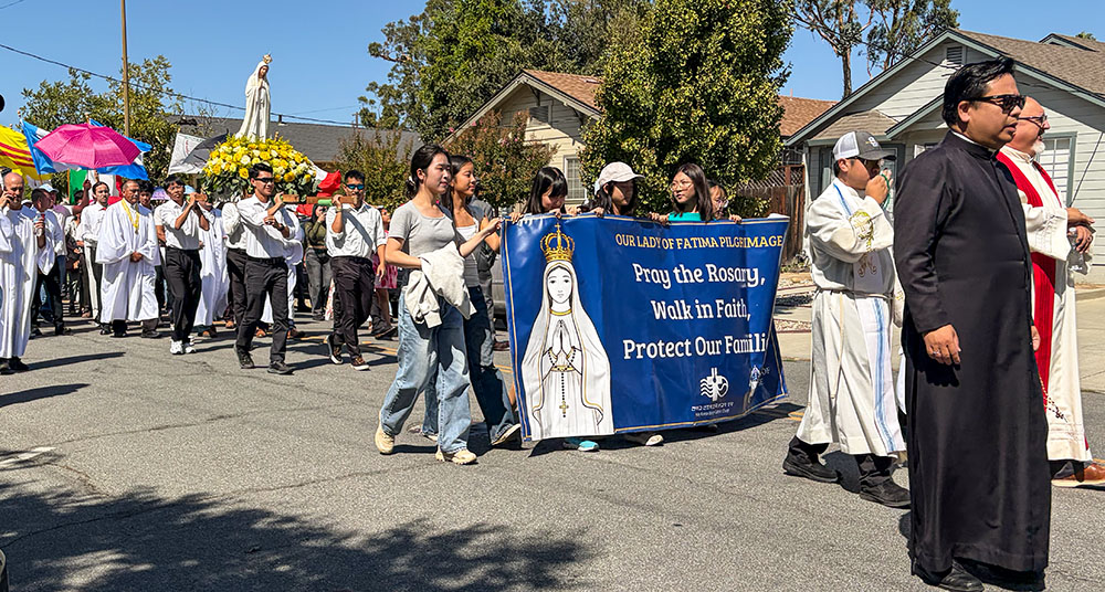 A banner in front of a statue of Our Lady of Fatima bears the words “Pray the Rosary, Walk in Faith, Protect Our Families,” during a procession in support of immigrants in San Jose, California, Sept.13, 2026. (Marissa Nichols)