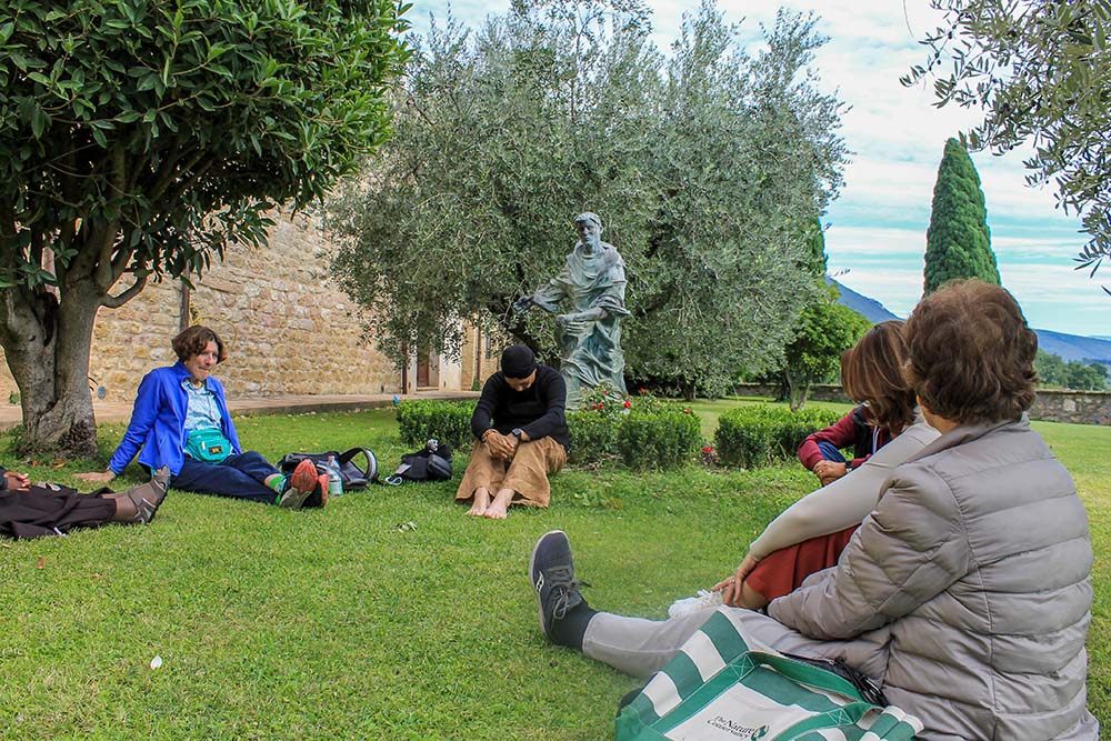 Pilgrims to Assisi, Italy, take part in a prayer service in the garden at the Church of San Damiano on Oct. 4, 2025, the feast of St. Francis. (NCR photo/Brian Roewe)