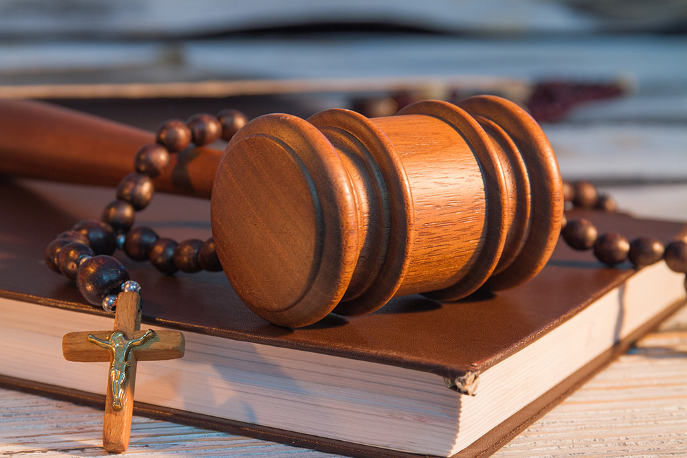 Gavel, law book and a rosary (Dreamstime/Denys Kovtun)