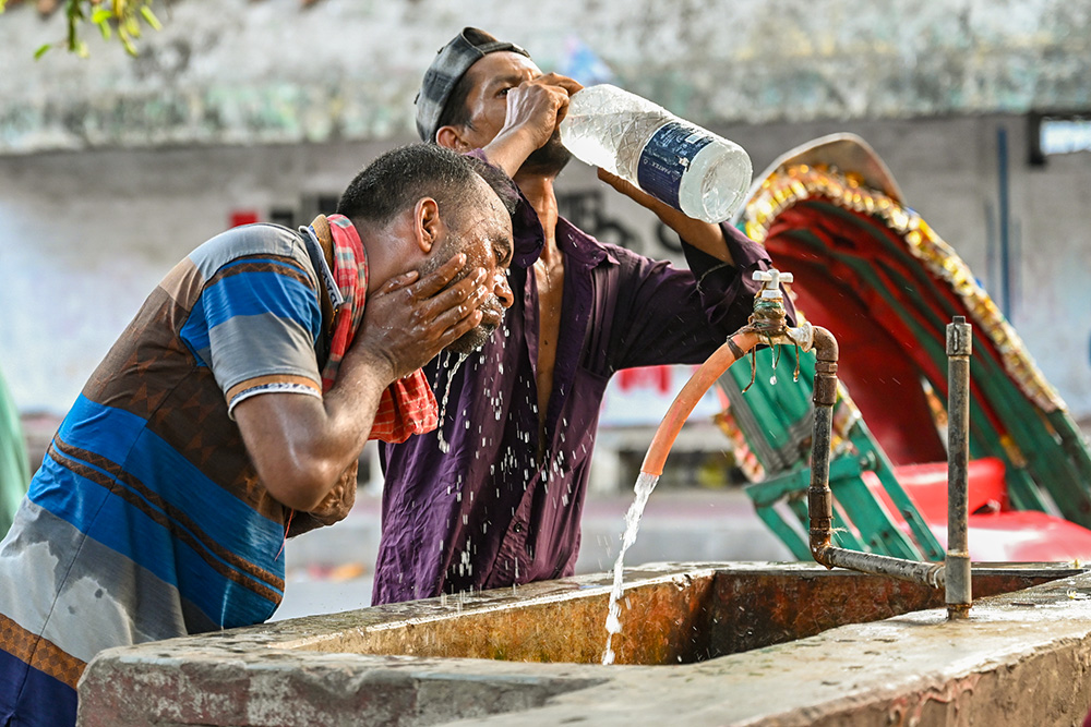 A rickshaw driver washes his face at a roadside water pipeline during a heat wave in Dhaka, Bangladesh, April 27, 2024. (Dreamstime/Mamunur Rashid)