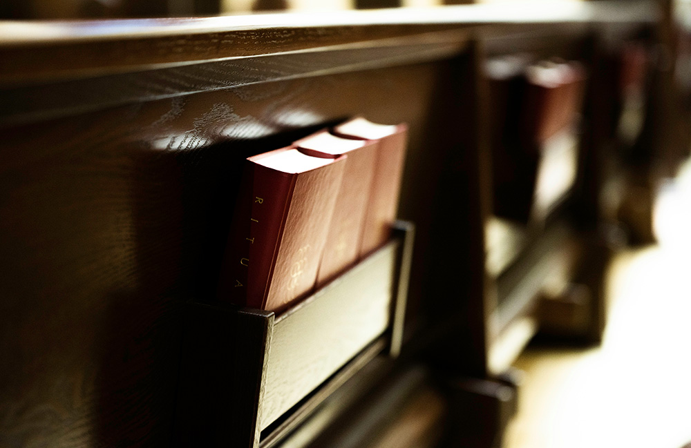 Pews with hymnals (Unsplash/Gianna B)