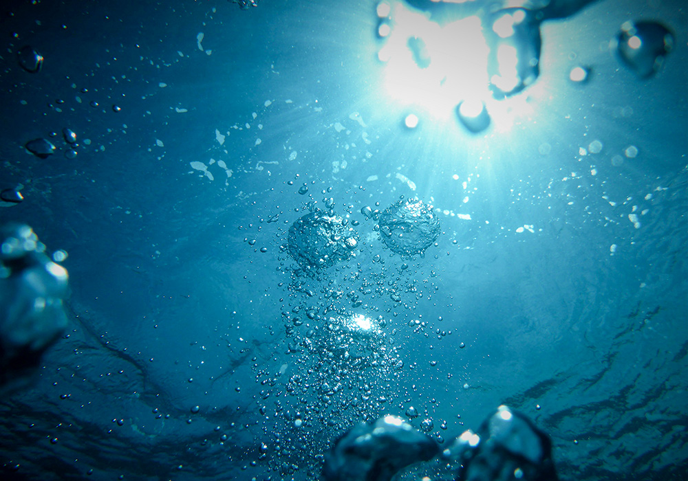 Bubbles underwater with sun shining through (Unsplash/Jong Marshes)