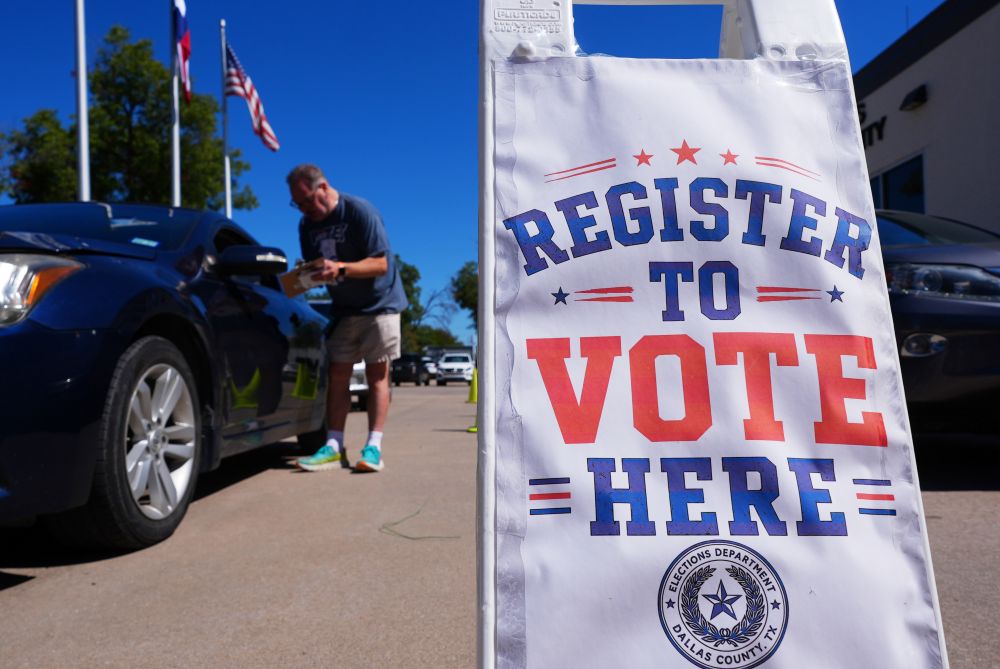 Volunteer Steven Marlin, left, helps a driver register to vote at a drive up location outside the Dallas CounElections Department in Dallas Monday, Oct. 5, 2026. (AP/LM Otero)