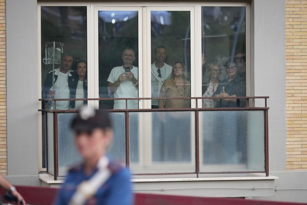 People crowd a window to watch Pope Leo XIV leave Rome's Gemelli hospital Oct. 17, 2026, after undergoing surgery Oct. 17 to remove lung cancer. (AP/Andrew Medichini)