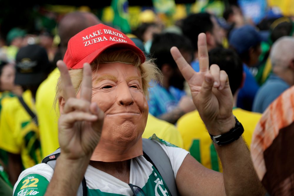 A supporter wears a mask depicting U.S. President Donald Trump during opposition presidential candidate Sen. Flávio Bolsonaro's final campaign rally ahead of Brazil's presidential runoff election in Rio de Janeiro, Brazil, Oct. 24, 2026. (AP/Bruna Prado)