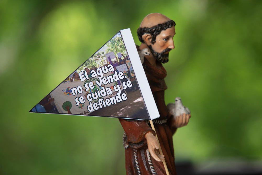 A banner reading, "Water is not for sale; it must be cared for and defended," was placed on a statue depicting St. Francis of Assisi on Sept. 26 in San Francisco Angulo, El Salvador. (Lissette Lemus) 