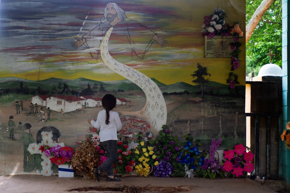 A 4-year-old girl plays in front of a mural commemorating the victims of the 1981 San Francisco Angulo massacre. (Lissette Lemus) 
