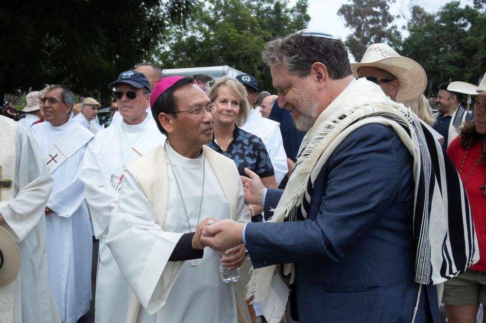 San Diego Bishop Michael Pham shakes hands with Rabbi Mike Rothbaum Sept. 27, 2026, after the bishop led more than 4,000 people in a procession on the World Day of Migrants and Refugees. (OSV News/David Maung)