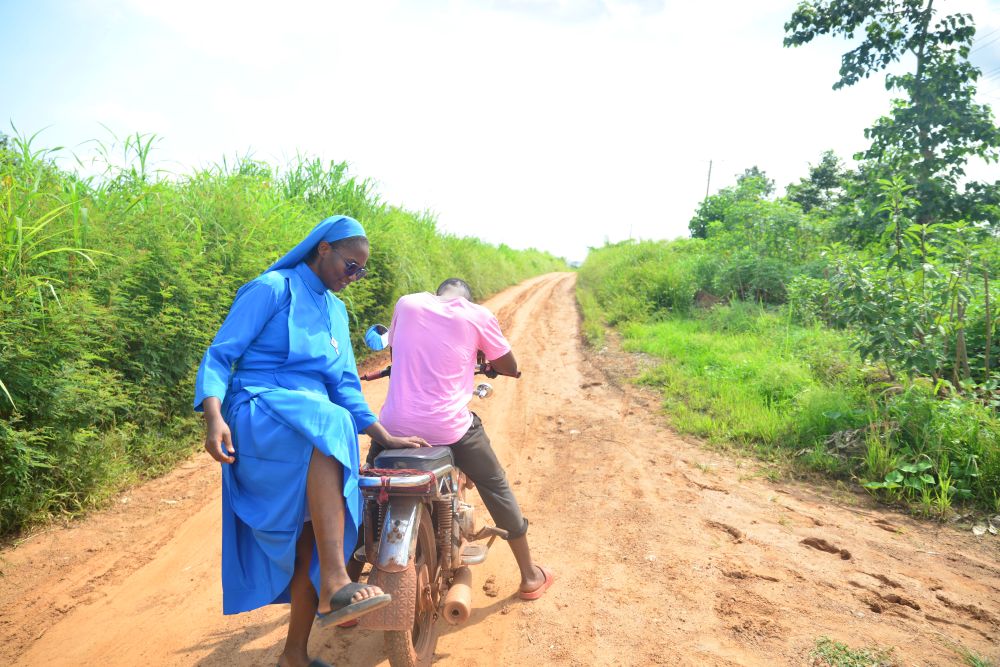 Daughter of Divine Love Sr. Jacinta Nwankwo mounts a motorcycle, which serves as the main means of transportation to Ezza-Nkwubor Nike, a remote village in Enugu State, southeast Nigeria. (Patrick Egwu)