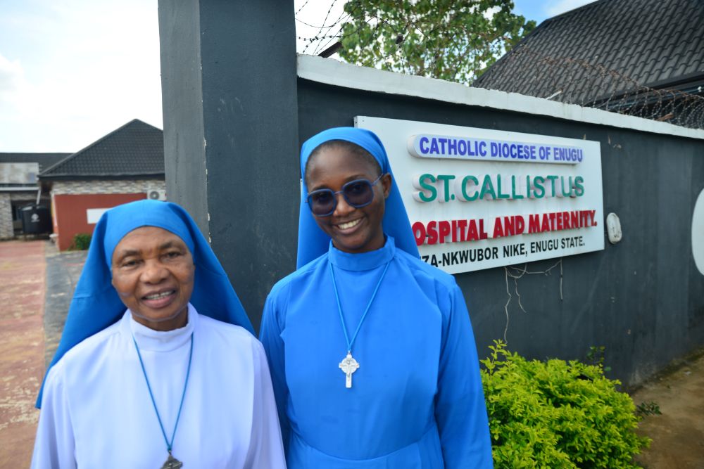 Daughters of Divine Love Srs. Mary Calisata Iwuji and Jacinta Nwankwo pose for a photo in front of the diocesan clinic in Ezza-Nkwubor Nike, a remote village in Enugu State, southeast Nigeria. (Patrick Egwu)