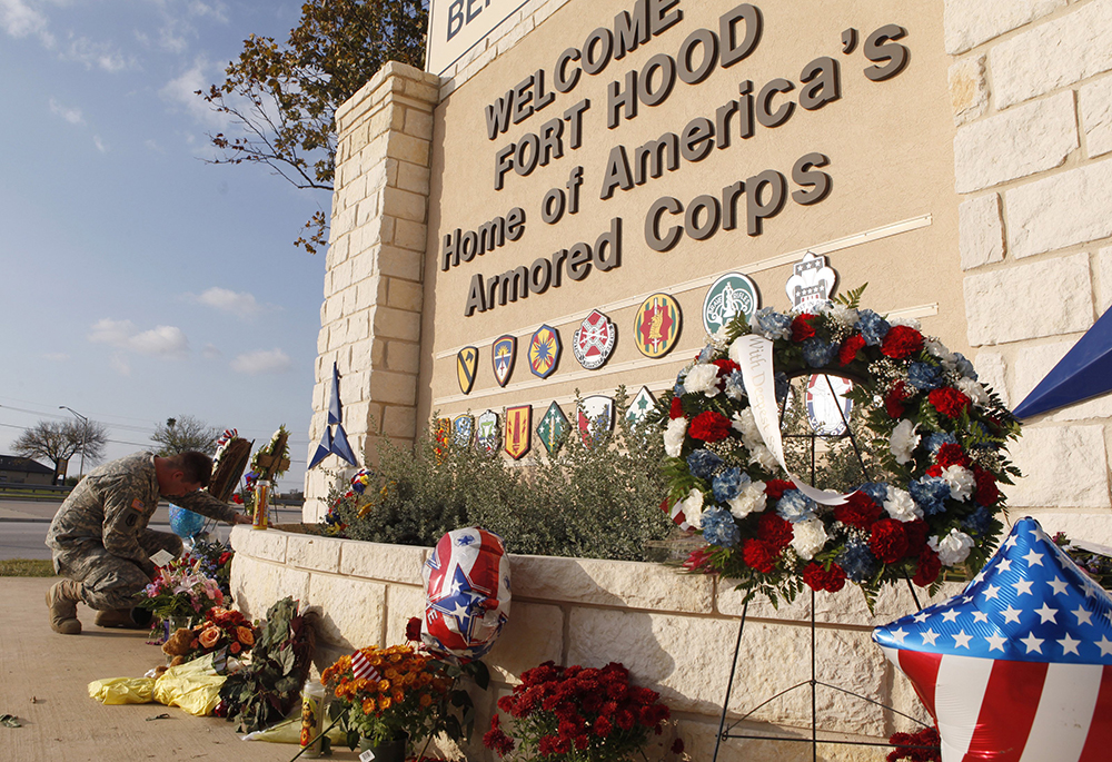 United States Army Specialist Robert Orcutt prays near a makeshift memorial for victims of the shootings at Fort Hood Army post in Fort Hood, Texas, Nov. 9, 2009. (OSV News/Reuters/Jessica Rinaldi) 