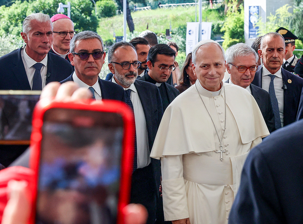 Pope Leo XIV smiles as a person takes a cellphone photo as the pontiff arrives at Rome's Gemelli Hospital Oct. 13, 2026, ahead of his surgery that afternoon. (OSV News/Reuters/Ciro De Luca)