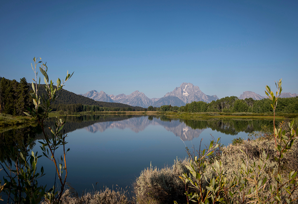 The Teton mountains reflect on Oxbow Bend in Grand Teton National Park in Moran, Wyoming, Aug. 22, 2025. (AP photo/Amber Baesler, File)