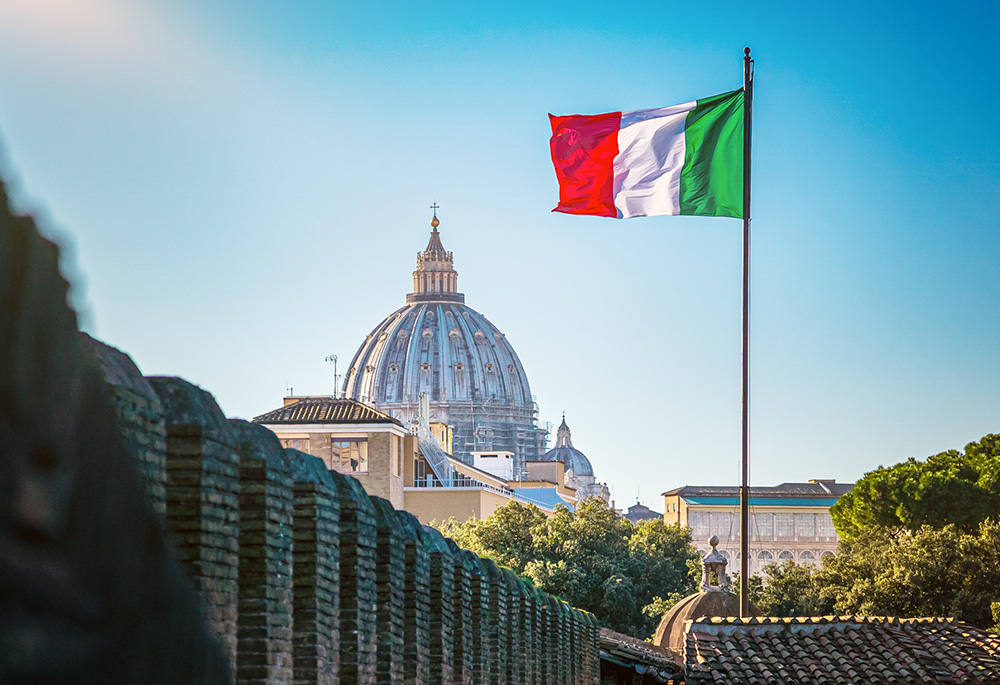 An Italian flag flies in Rome, with the dome of St. Peter's Basilica at the Vatican seen in the background. (Dreamstime/Vchalup)