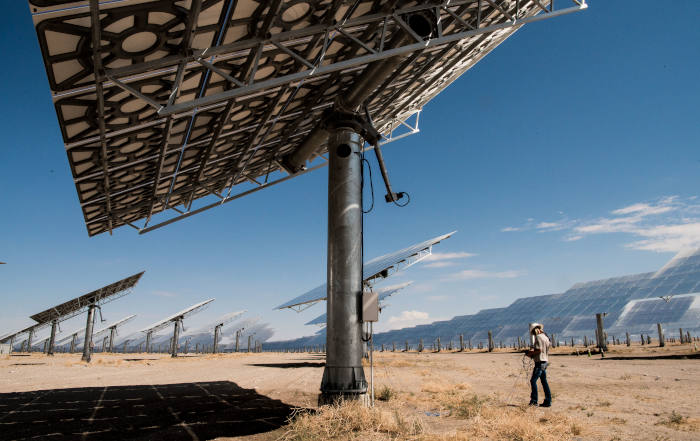 An employee runs diagnoses on heliostats at the Crescent Dunes Solar Thermal Facility in the Nevada desert in this July 2017 photo. (Climate Visuals/Dennis Schroeder/National Renewable Energy Lab)