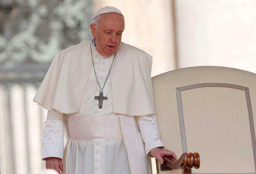 Pope Francis holds onto the arm of his chair as he arrives for the general audience in St. Peter's Square at the Vatican April 20. Since February, the pope, who has long suffered from sciatica, has repeatedly had difficulty walking, resulting in a number 