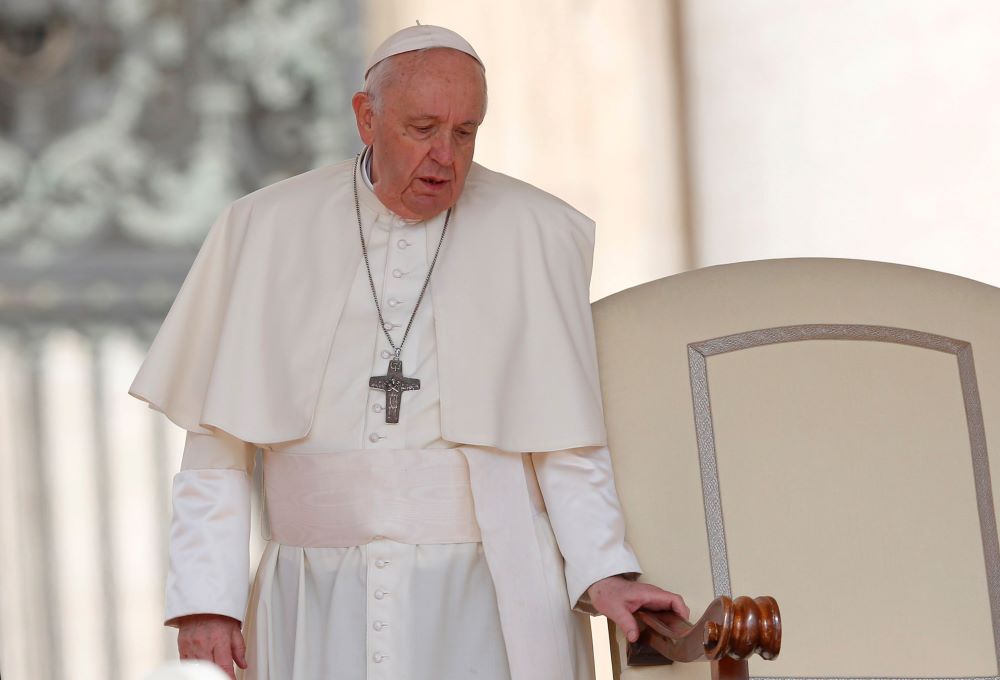 Pope Francis holds onto the arm of his chair as he arrives for the general audience in St. Peter's Square at the Vatican April 20. Since February, the pope, who has long suffered from sciatica, has repeatedly had difficulty walking, resulting in a number