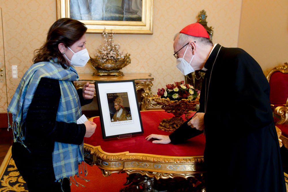Caroline Weijers, ambassador of the Netherlands to the Holy See, presents a Vatican postage stamp showing Pope Adrian VI to Cardinal Pietro Parolin, Vatican secretary of state, at the Vatican March 4. (CNS/Vatican Media)