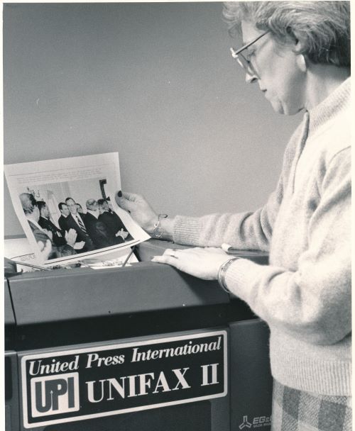 Barbara Stephenson, then Catholic News Service's photo editor, receives an image from the United Press International "Unifax II" machine in this 1990 file photo. (CNS)