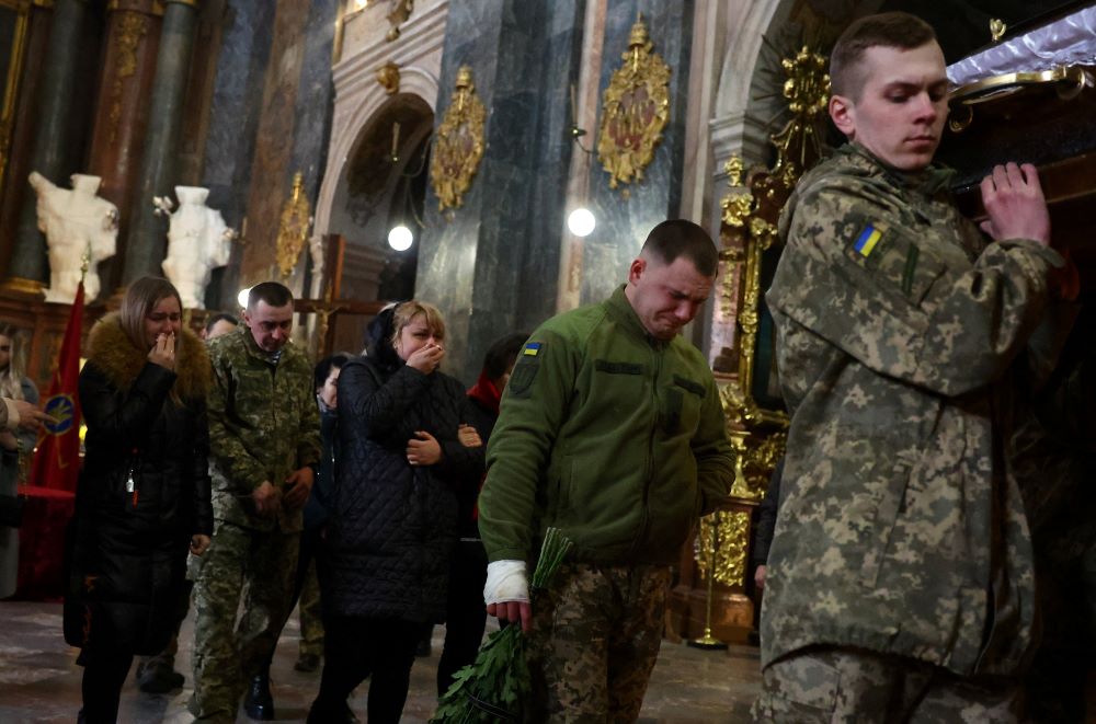 Family members and comrades mourn during the funeral of a fallen soldier at the Catholic Church of the Holy Apostles Peter and Paul in Lviv, Ukraine, March 16. (CNS/Reuters/Kai Pfaffenbach)