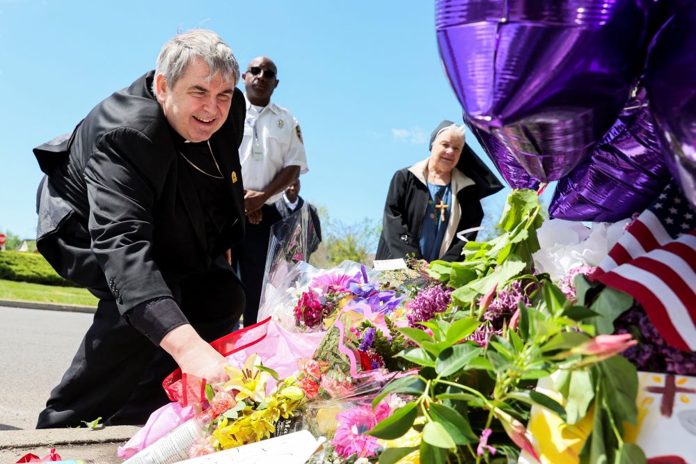 Bishop Michael W. Fisher of Buffalo, New York, places flowers at a memorial May 17, 2022, after a mass shooting at a Tops supermarket. The accused shooter is a white man who espoused white supremacist ideas and whose writings indicate he intentionally tar