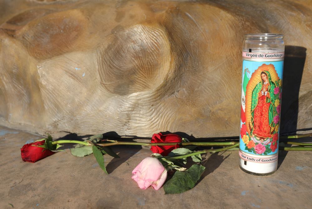 A candle and roses are pictured outside the Sanctuary of Our Lady of Guadalupe in Santa Fe, N.M., May 20, 2021. (CNS/Bob Roller)