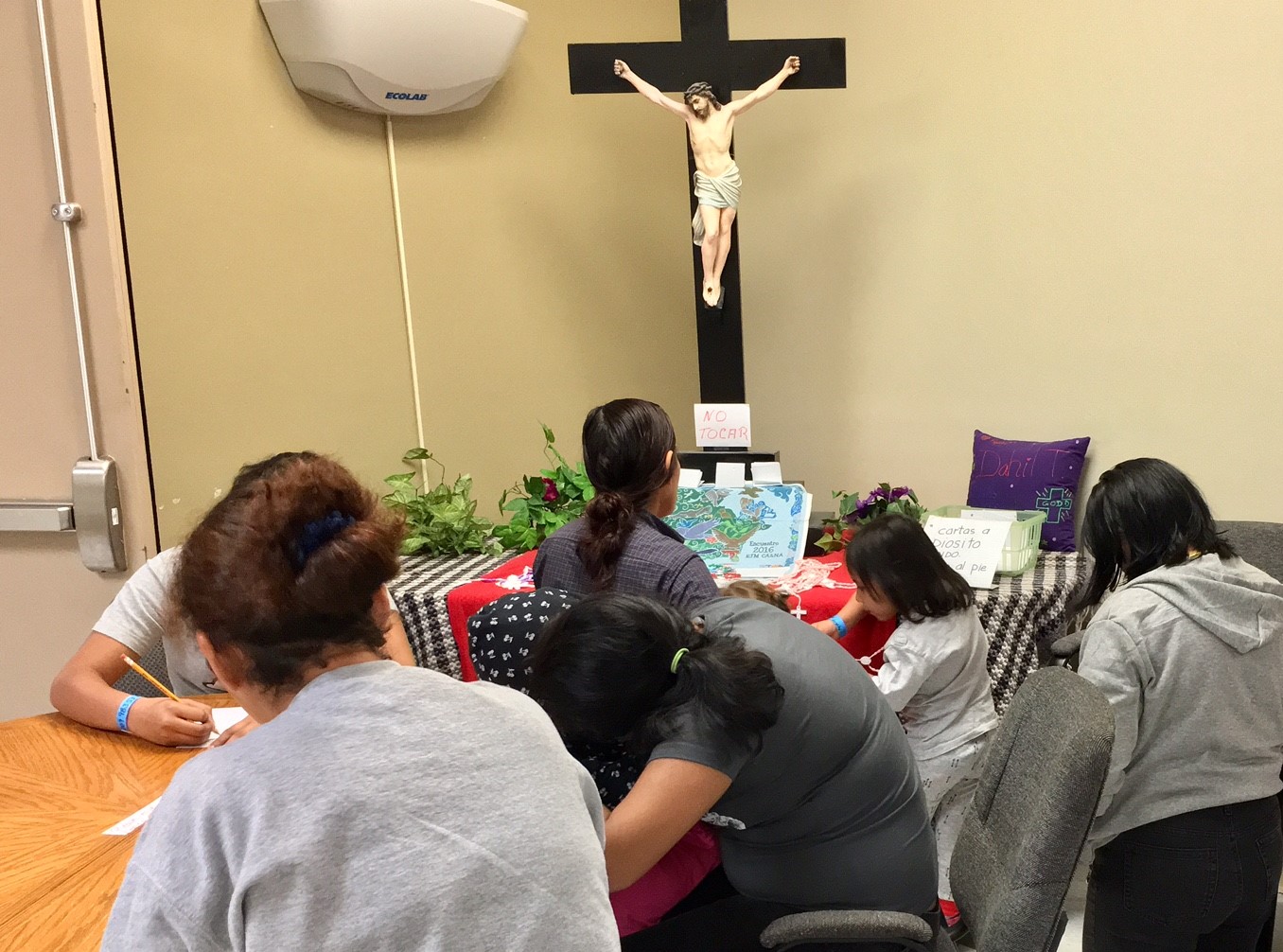 A group of immigrants pray at the Casa del Refugiado immigrant shelter in El Paso, Texas. (Courtesy of Pauline Hovey)