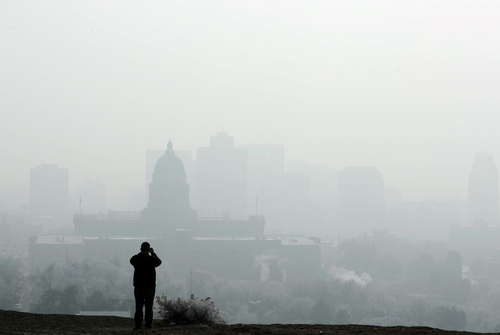 A man stops to take a picture of the Utah State Capitol and buildings that are shrouded in smog in downtown Salt Lake City Dec. 12, 2017. (CNS/Reuters/George Frey)