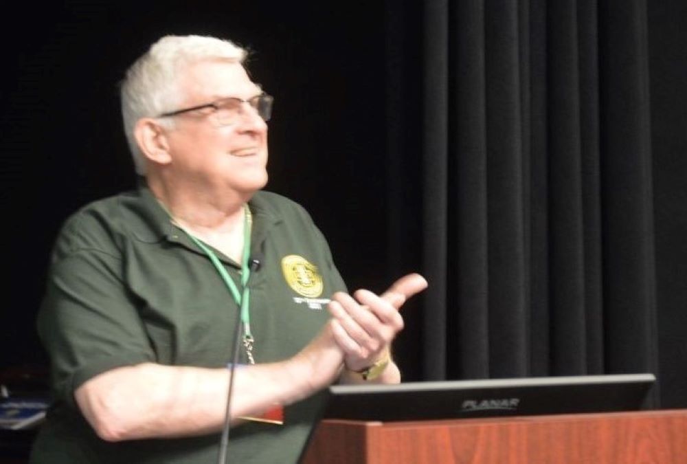 Holy Cross Fr. Stephen Newton, who serves as executive director of the Association of U.S. Catholic Priests, speaks at the podium during the AUSCP's 2022 annual assembly. (Courtesy of AUSCP)