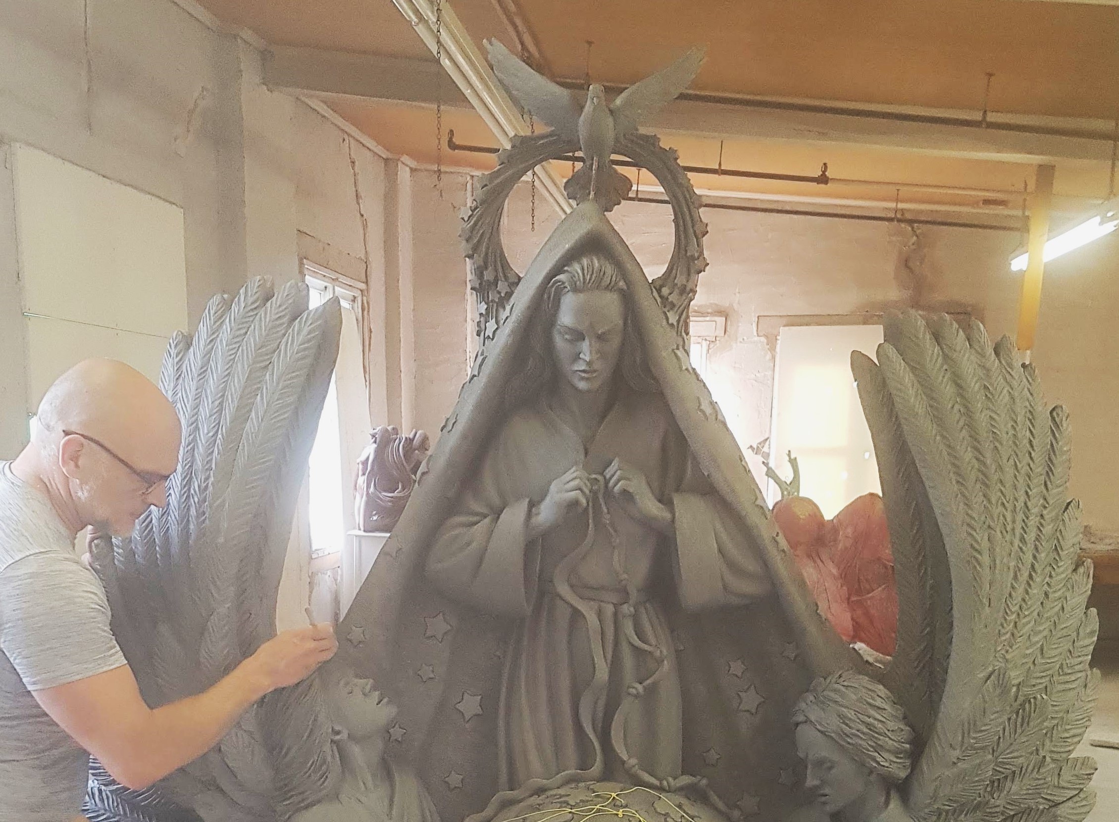 Timothy Schmalz works in his studio on the statue Mary, Untier of Knots. His 20-foot bronze Angels Unawares, which depicts migrants and refugees crammed aboard a boat as they flee, found a home in St. Peter's Square. (Courtesy of Timothy Schmalz)