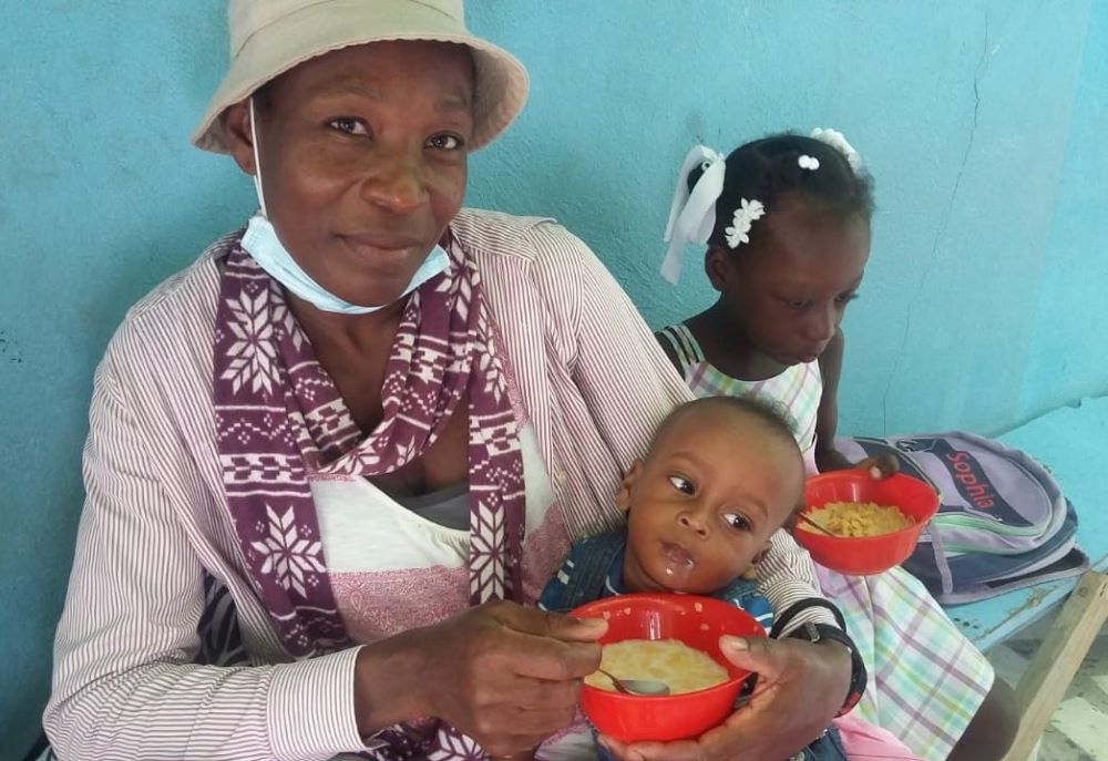 Children eat with their mother in the Brazilian inter-congregational mission in Port-au-Prince, Haiti. (Courtesy of Sr. Ideneide Rêgo)