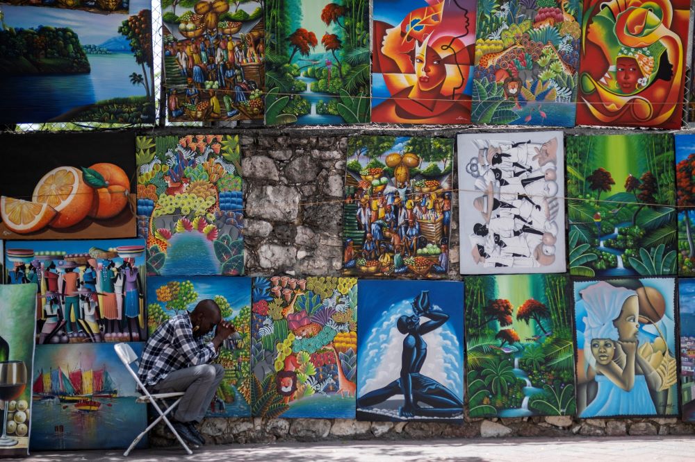 A street art vendor In Port-au-Prince, Haiti, prays about a week after the July 7 assassination of Haitian President Jovenel Moïse. (CNS