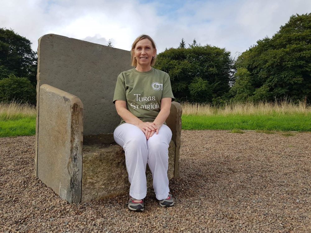 Linda Ervine sits on a replica of the ancient stone chair used to inaugurate the Gaelic Chieftains of Clandeboye in Northern Ireland. Ervine, founder of Northern Ireland's first integrated Irish language preschool, has faced bullying and intimidation. (Pr