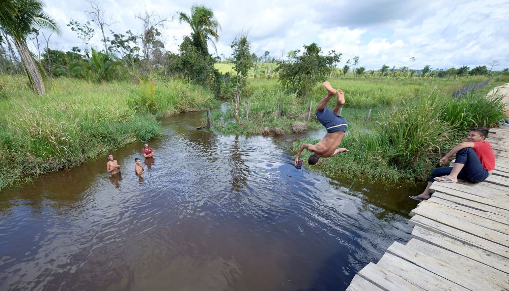 Children jump from a rickety bridge into a river near Anapu, Brazil, March 14, 2019. (CNS/Paul Jeffrey)
