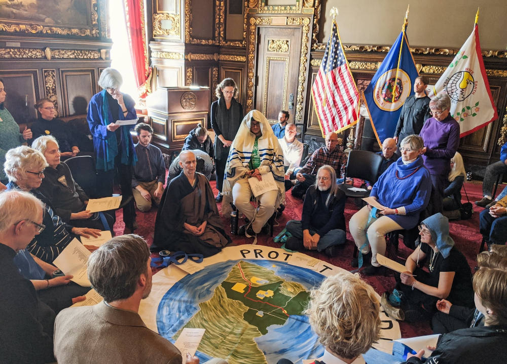 Faith leaders form a prayer circle inside the office of Minnesota Gov. Tim Walz as part of an action opposing the Enbridge Line 3 pipeline in February 2020. (Minnesota Interfaith Power & Light)