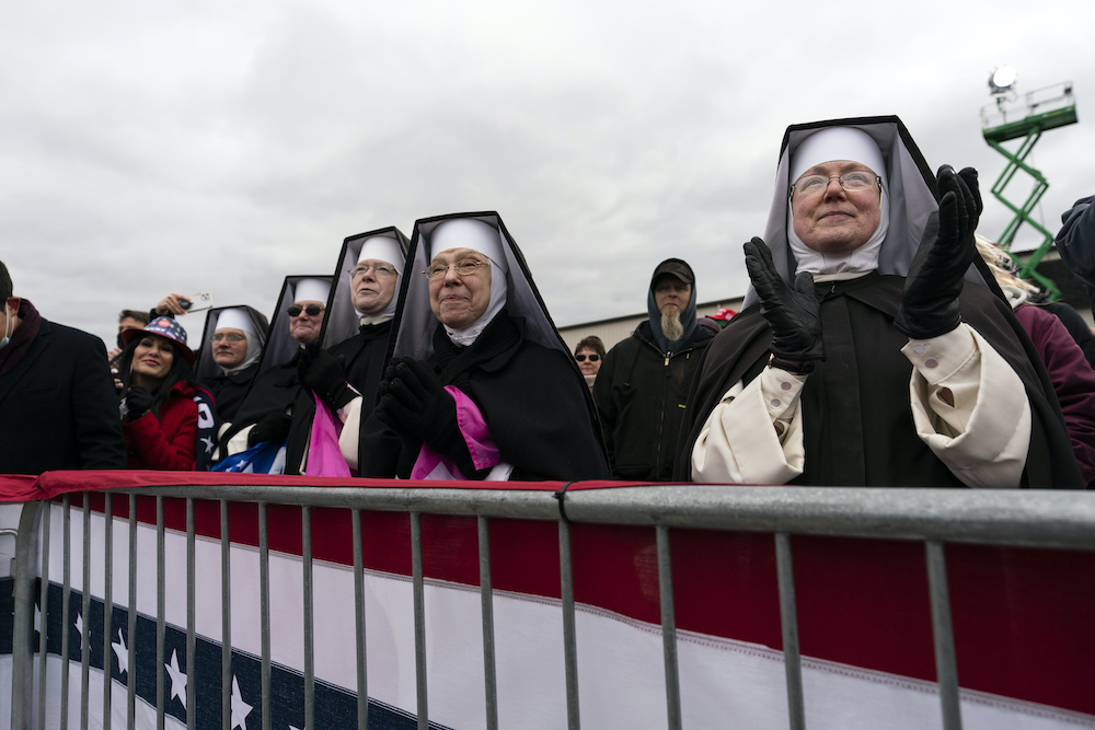 Dominican Sisters of the Immaculate Heart of Mary, based in Hartland, Michigan, and who do not have canonical standing with the Catholic Church, applaud as then President Donald Trump speaks at a campaign rally Oct. 30, 2020. (AP/Alex Brandon)