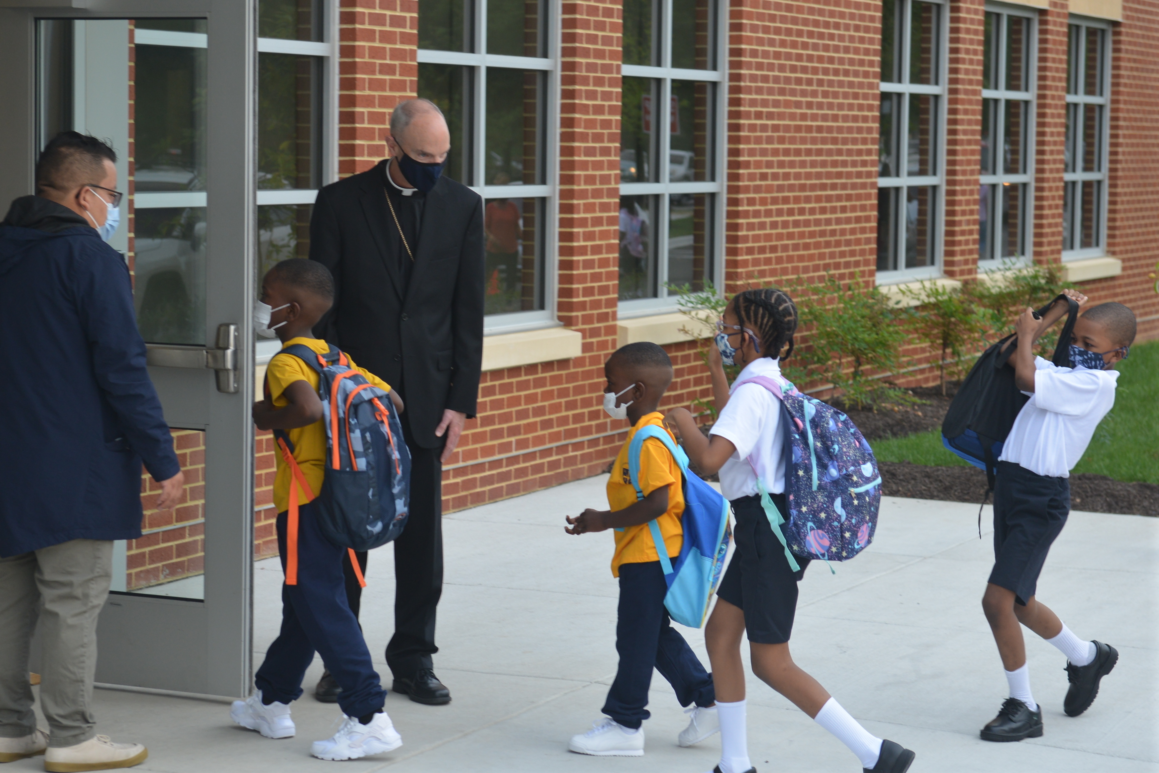 Youngsters enter the first new Catholic school built in Baltimore in roughly 60 years with a mix of enthusiasm and first-day-back jitters, Monday Aug. 30, 2021. (AP Photo/David McFadden)