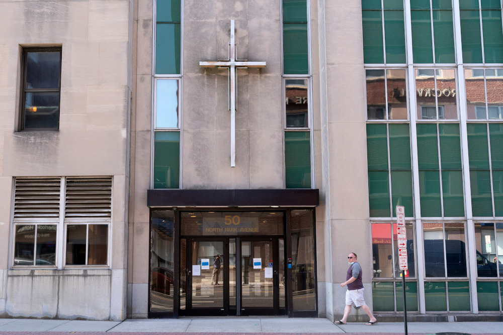 A man walks by the offices of the Diocese of Rockville Centre Oct. 1, 2020. Rockville Centre was the fourth New York diocese to file for bankruptcy because of financial pressure from lawsuits over past sexual abuse by clergy members. New York's