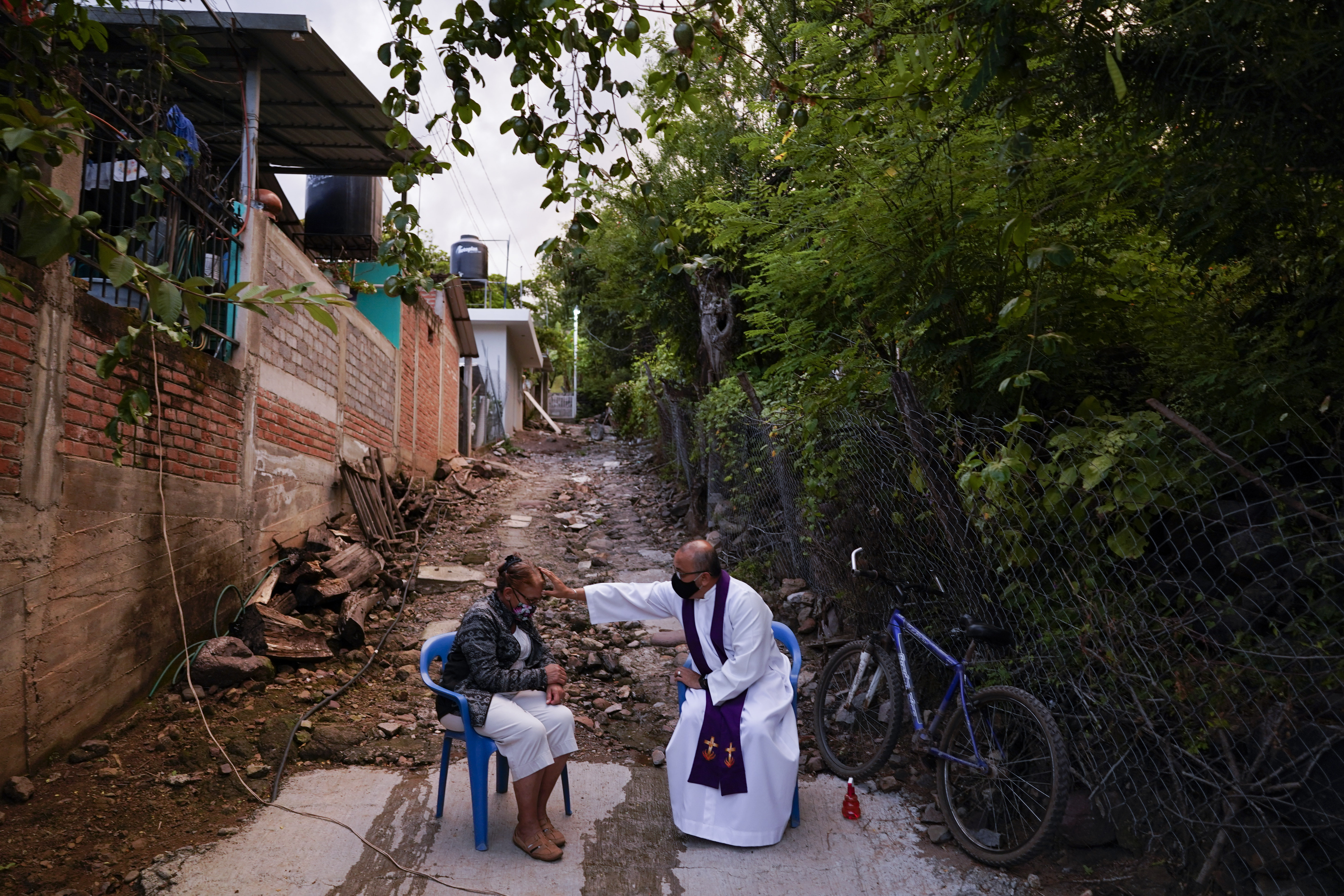Rev. Gilberto Vergara blesses a person giving confession in Aguililla in the Michoacan state of Mexico, Friday, Oct. 29, 2021. (AP Photo/Eduardo Verdugo) Rev. Gilberto Vergara blesses a person giving confession in Aguililla in the Michoacan state of Mexico, Friday, Oct. 29, 2021. (AP Photo/Eduardo Verdugo)