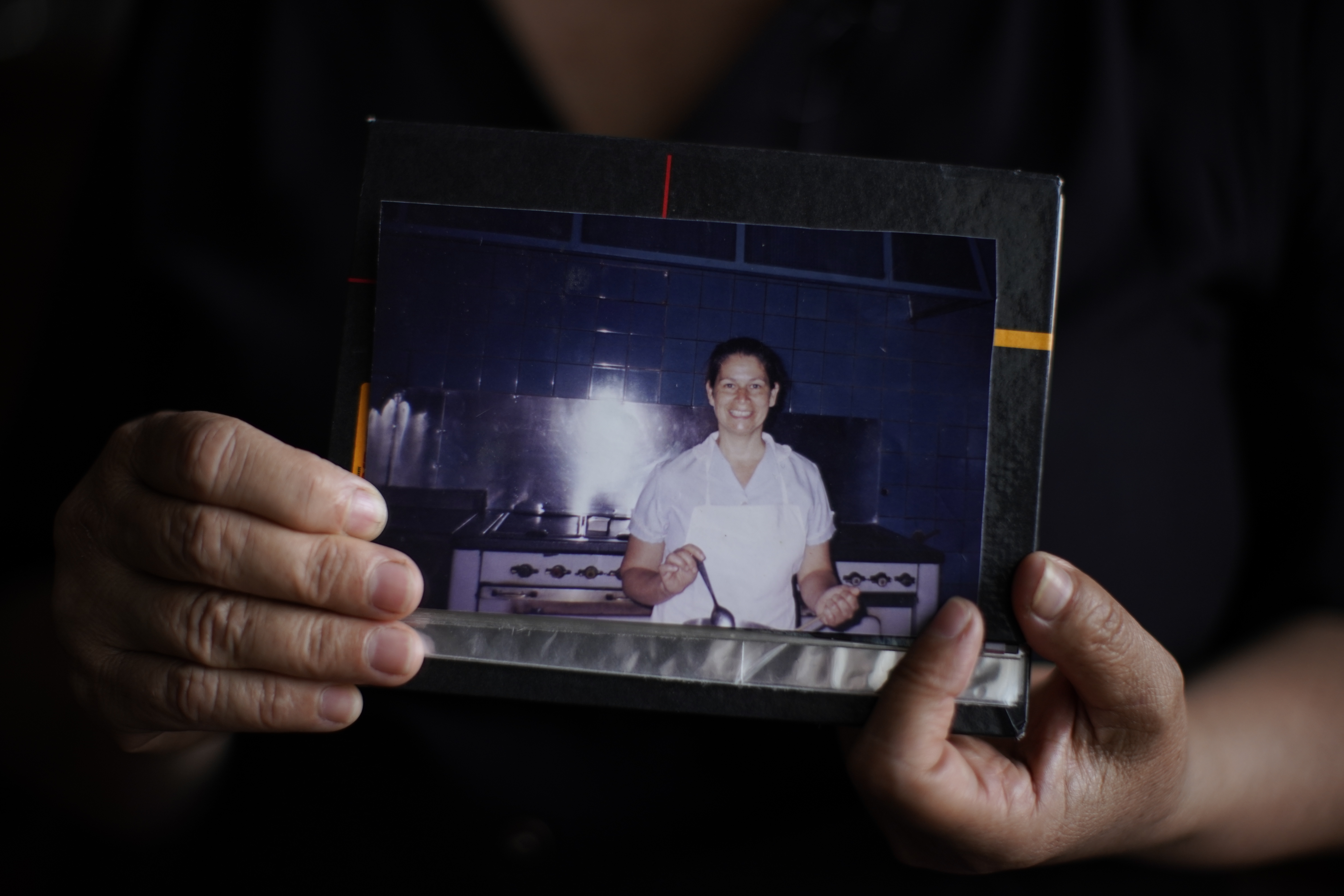 Beatriz Delgado holds an undated photo of herself working in the kitchen of an Opus Dei house, in Buenos Aires, Argentina, Thursday, Nov. 4, 2021. (AP Photo/Victor R. Caivano)