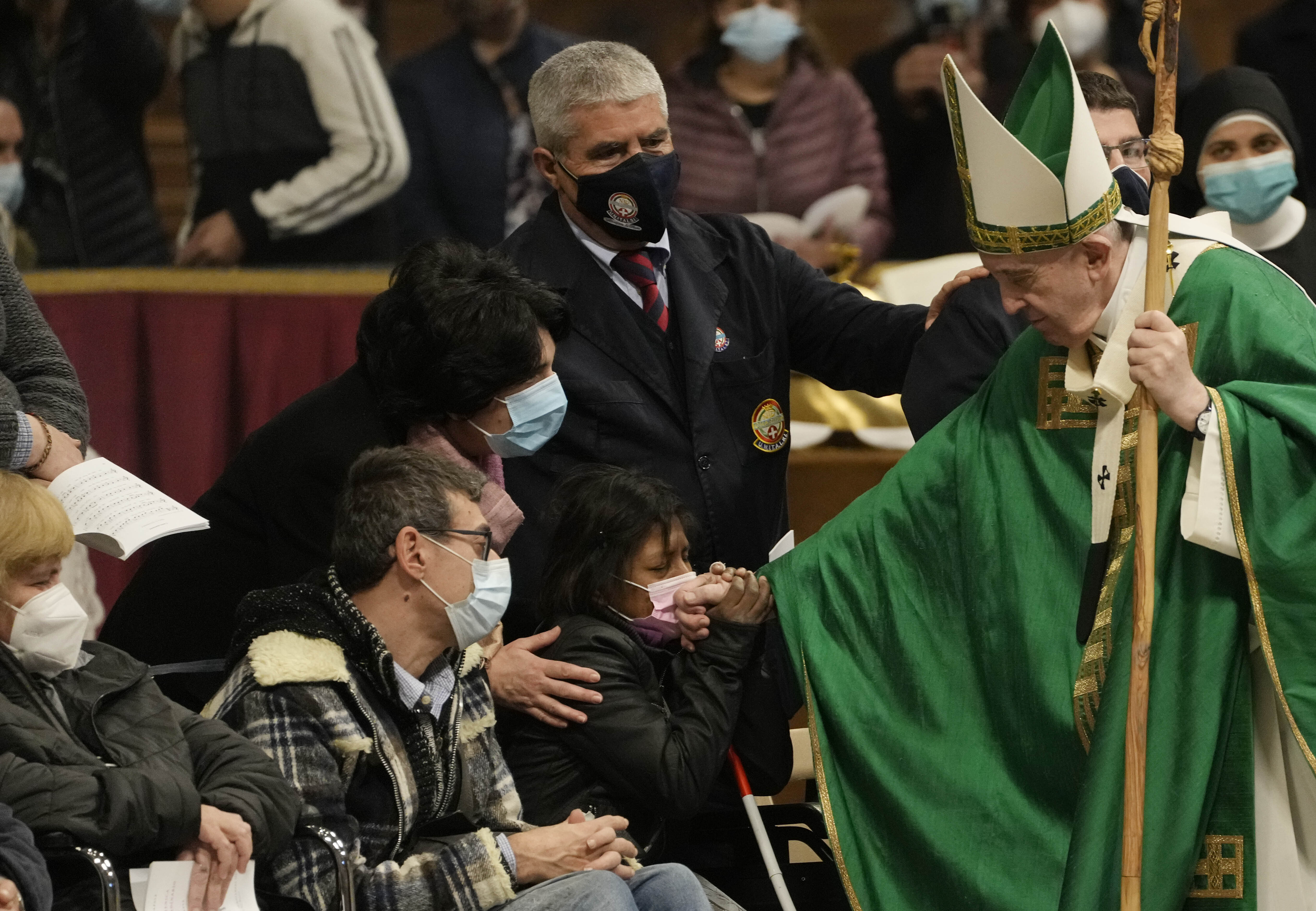 Pope Francis greets faithful at the end of a Mass on the Day of the Poor in St. Peter's Basilica, at the Vatican, Sunday, Nov. 14, 2021. (AP Photo/Gregorio Borgia)