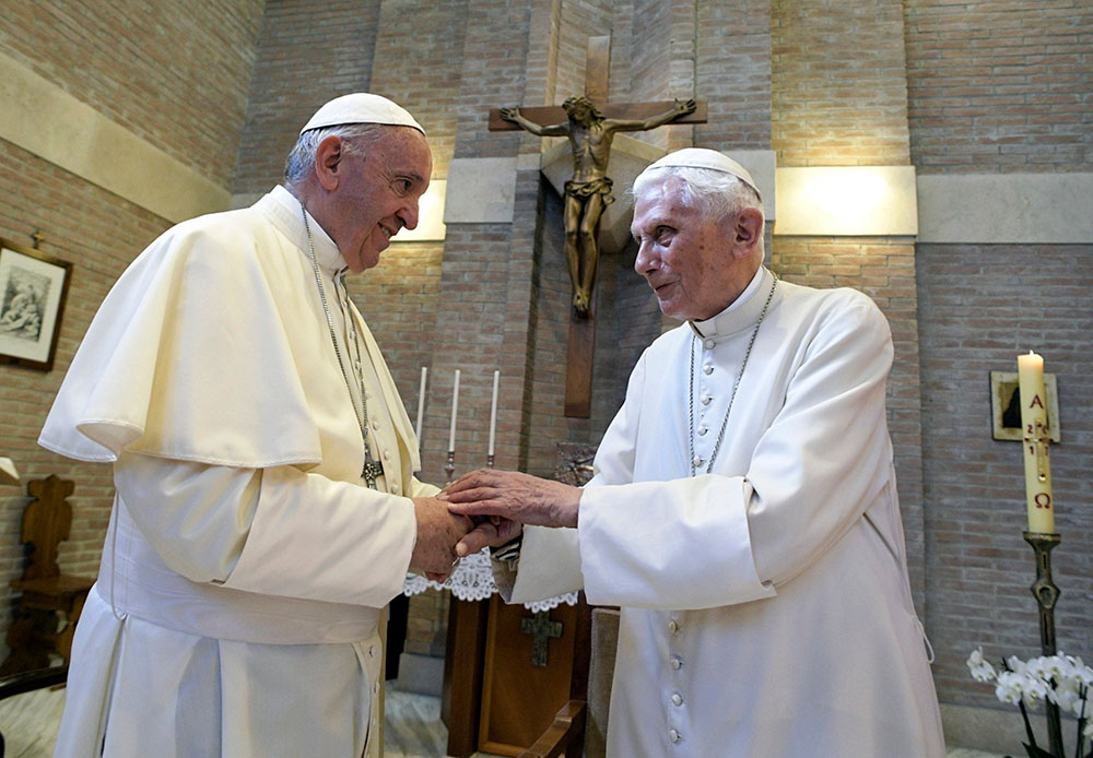 In 2017, Pope Francis, left, and Pope Emeritus Benedict XVI meet on the occasion of the elevation of five new cardinals at the Vatican. (RNS/Pool photo via AP, File/L'Osservatore Romano)