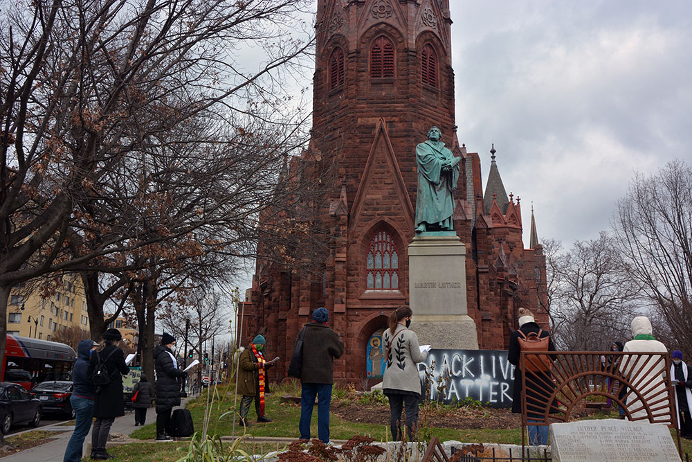 An interfaith group of religious leaders prays outside of Luther Place Memorial Church on Jan 6 in Washington. (RNS/Jack Jenkins)