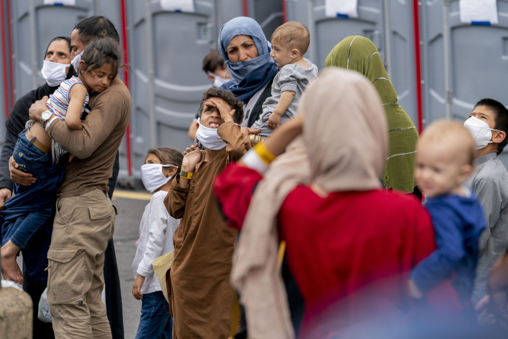 People evacuated from Afghanistan step off a bus as they arrive at a processing center Aug. 23 in Chantilly, after arriving on a flight at Dulles International Airport. (AP/Andrew Harnik)