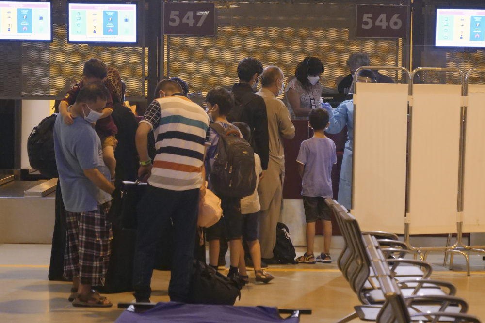 Evacuees from Afghanistan queue in line after arriving at Rome's Leonardo da Vinci international airport in Fiumicino Aug. 24. (AP/Paolo Santalucia)